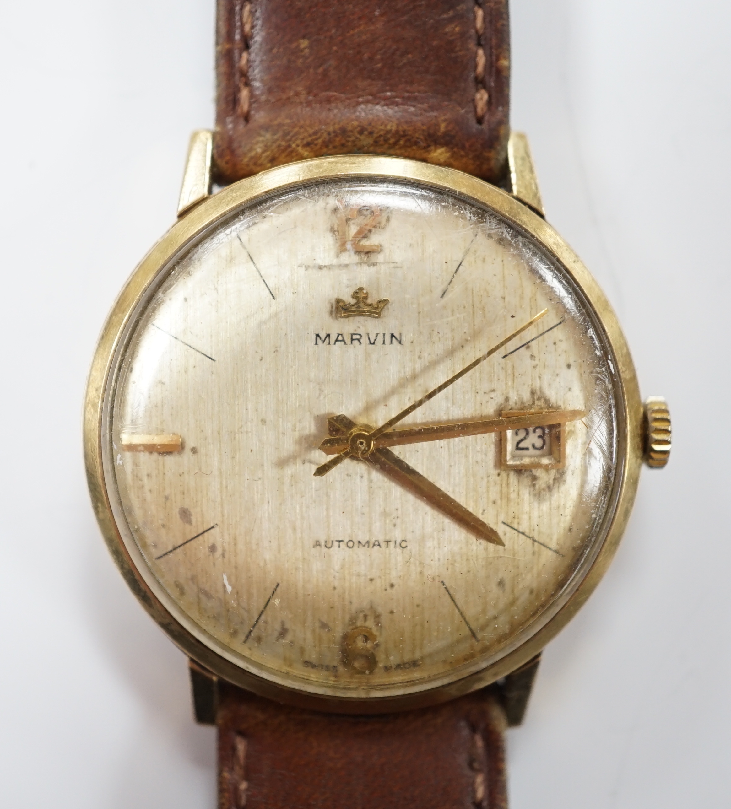 A gentleman's 9ct gold Marvin automatic wrist watch, with date aperture, on a leather strap.